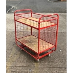 red_picking_trolley_small_and_rigid_with_3_mesh_sides_and_2_swivel_and_2_fixed_castors_also_a_4th_side_above_the_maincompartment_to_allow_the_top_shelf_to_be1